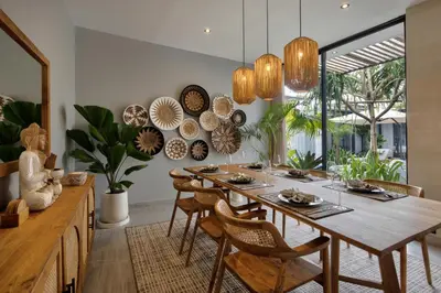 a dining room with a large wooden table and chairs at Ananda Villa by Betterplace in Jimbaran