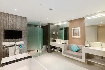 a bathroom with two sinks and a tv and two mirrors at Double - Six, Luxury Hotel - Seminyak in Seminyak