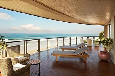 a balcony with chairs and a view of the beach at Double - Six, Luxury Hotel - Seminyak in Seminyak