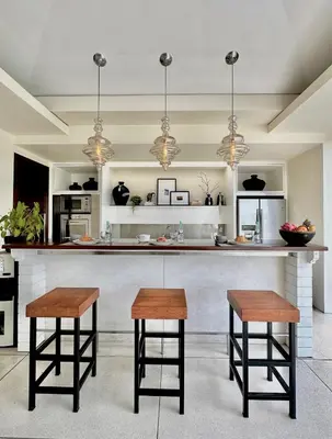 a kitchen with a counter and two stools at VILLA CELAVI 15 in Kerobokan