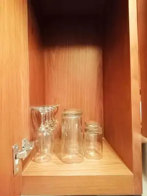 a wooden cabinet with glass jars on a shelf at The Palmana Courtyard Jayakarta Residence 2 in Seminyak