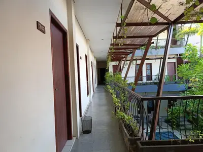an empty hallway of a building with plants at Keola Hotel Legian in Legian