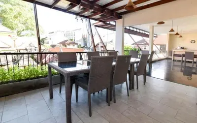 a dining room with a table and chairs on a balcony at Keola Hotel Legian in Legian