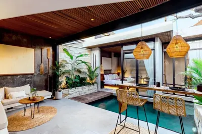 an outdoor living room with a pool and a house at Danu Villas Bali in Kerobokan