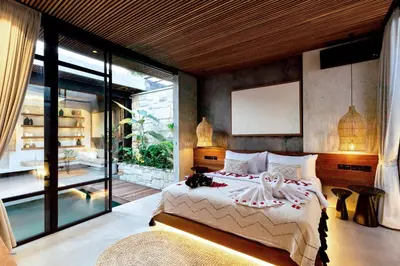 a bedroom with a bed and a large window at Danu Villas Bali in Kerobokan