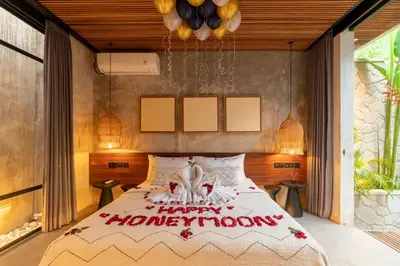 a bedroom with a bed with a happy homiversary sign on it at Danu Villas Bali in Kerobokan