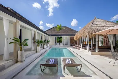 a villa with a swimming pool and a resort at Villa Matahari - Seminyak in Seminyak