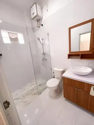 a bathroom with a shower and a toilet and a sink at Kubu19 Guest House in Seminyak