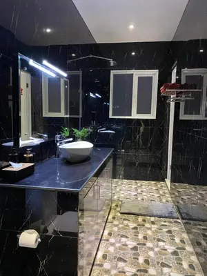 a black bathroom with a sink and two mirrors at Villa Mabuk in Legian