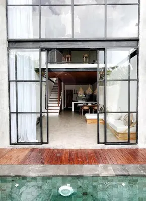 a glass house with a pool in front of it at TropicalLoft With Ocean View From Rooftop -RARE! in Canggu