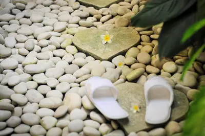 a pair of shoes on a pebble ground with hearts at Villa Domus De Janas in Seminyak