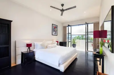 a bedroom with a white bed and a large window at The Lookout Villa Jimbaran By Island Escape in Jimbaran