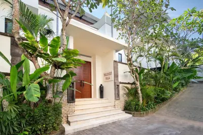 a house with a wooden door and some trees at The Lookout Villa Jimbaran By Island Escape in Jimbaran