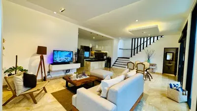 a living room with white furniture and a tv at Solaris Private Villa Club Residence Canggu in Canggu