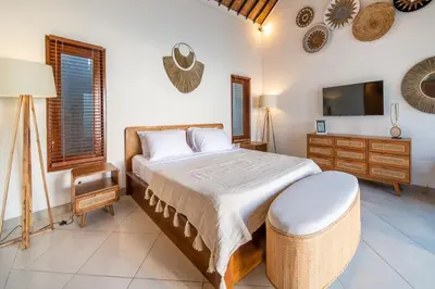 a bedroom with a large bed and a tv at 2 bedroom Balinese private pool villa in Seminyak in Seminyak