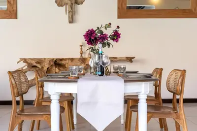 a dining room table with a vase of flowers on it at 2 bedroom Balinese private pool villa in Seminyak in Seminyak