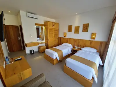 a hotel room with two beds and a television at Kamandaka in Kuta
