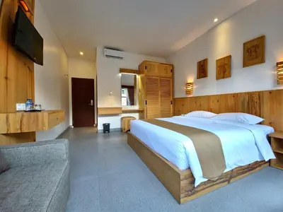 a bedroom with a large bed and a couch at Kamandaka in Kuta