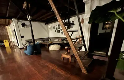 a living room with a wooden floor and a ladder at My Secret Home in Seminyak