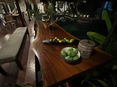 a wooden table with a bowl of fruit on it at My Secret Home in Seminyak