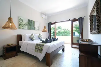 a bedroom with a white bed and a large window at Villa MARIE - KUTA - 6 Bedroom 4 Bathroom Villa - Great Location ! in Kuta