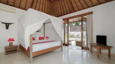 a bedroom with a bed with a mosquito net at Ku Estate by Villa Finder in Seminyak