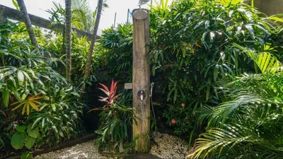 a wooden gate in a garden with plants at Ku Estate by Villa Finder in Seminyak
