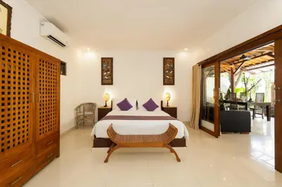 a bedroom with a large bed in a room at Villa Belharra in Seminyak