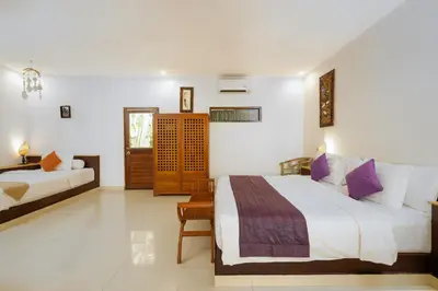 a hotel room with two beds and a desk at Villa Belharra in Seminyak