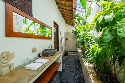 a bathroom with a sink and some plants at Villa Belharra in Seminyak