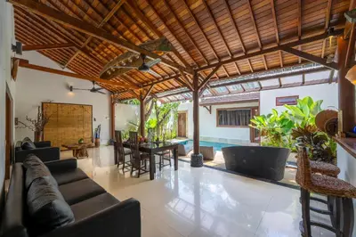 a living room with a couch and a table and chairs at Villa Belharra in Seminyak
