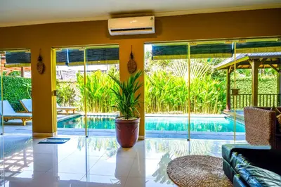 a living room with a pool and a plant at Villa LOGAN - KUTA - 5 Bedroom - 3 Bathroom Villa - Great Location in Kuta