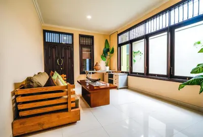 a living room with a couch and a table and windows at Villa LOGAN - KUTA - 5 Bedroom - 3 Bathroom Villa - Great Location in Kuta