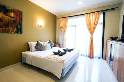 a bedroom with a bed and a large window at Villa LOGAN - KUTA - 5 Bedroom - 3 Bathroom Villa - Great Location in Kuta