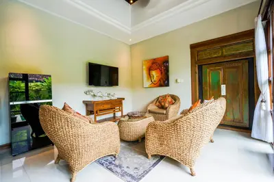 a living room with wicker chairs and a television at Villa VINO - LEGIAN - 3 bedroom - 3 bathroom Villa - Great Location in Seminyak