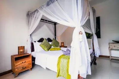 a bedroom with a white bed with a canopy at Villa VINO - LEGIAN - 3 bedroom - 3 bathroom Villa - Great Location in Seminyak