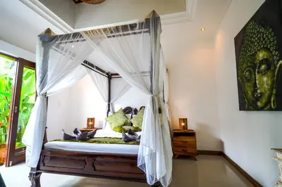 a bedroom with a canopy bed with white curtains at Villa VINO - LEGIAN - 3 bedroom - 3 bathroom Villa - Great Location in Seminyak