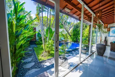 a room with a view of a pool and plants at Villa CONOR - LEGIAN - SEMINYAK - 2 Bedroom 2 Bathroom Villa - Great Location in Seminyak