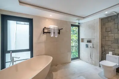 a bathroom with a tub and a toilet and a window at New Villa Selamanya in Ujung
