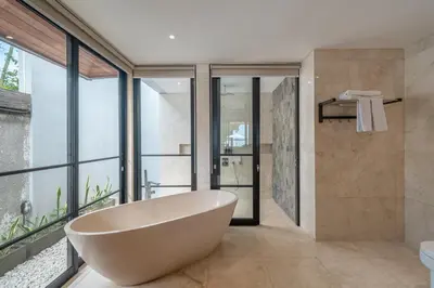 a bathroom with a large tub and glass windows at New Villa Selamanya in Ujung