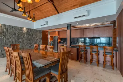a dining room with a large wooden table and chairs at New Villa Selamanya in Ujung