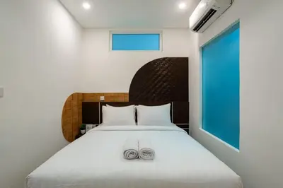 a bedroom with a bed with two slippers on it at Cove De Tinaya in Legian