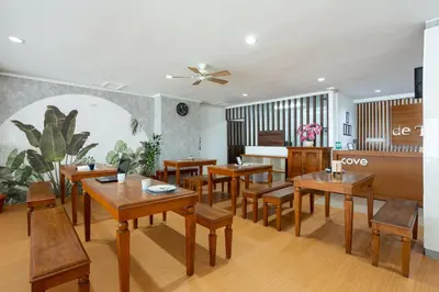 a dining room with wooden tables and chairs at Cove De Tinaya in Legian