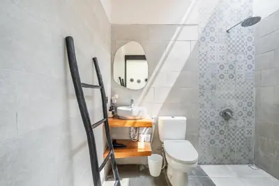 a bathroom with a toilet and a sink and a mirror at The R Villa Kaba - incl. Motorbikes in Seminyak