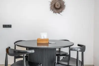 a table and chairs in a room with a wall at The R Villa Kaba - incl. Motorbikes in Seminyak