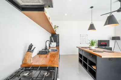 a kitchen with a wooden counter top and a stove at The R Villa Kaba - incl. Motorbikes in Seminyak