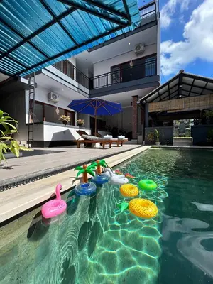 a house with a swimming pool with inflatable toys in it at James Guest House in Seminyak