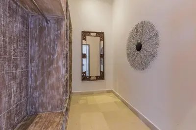 a hallway with a wooden door and a mirror at Villa Budha 1: 4bedrs 12m Pool, 700m2 garden with BBQ in Seminyak