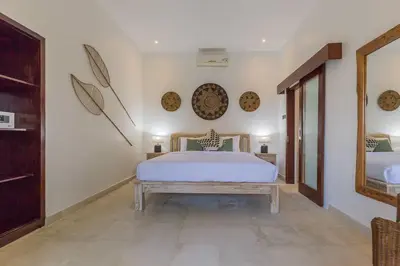 a bedroom with a bed and a table and a mirror at Villa Budha 1: 4bedrs 12m Pool, 700m2 garden with BBQ in Seminyak