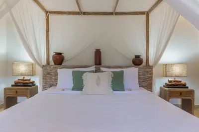 a bedroom with a large white bed with two lamps at Villa Budha 1: 4bedrs 12m Pool, 700m2 garden with BBQ in Seminyak